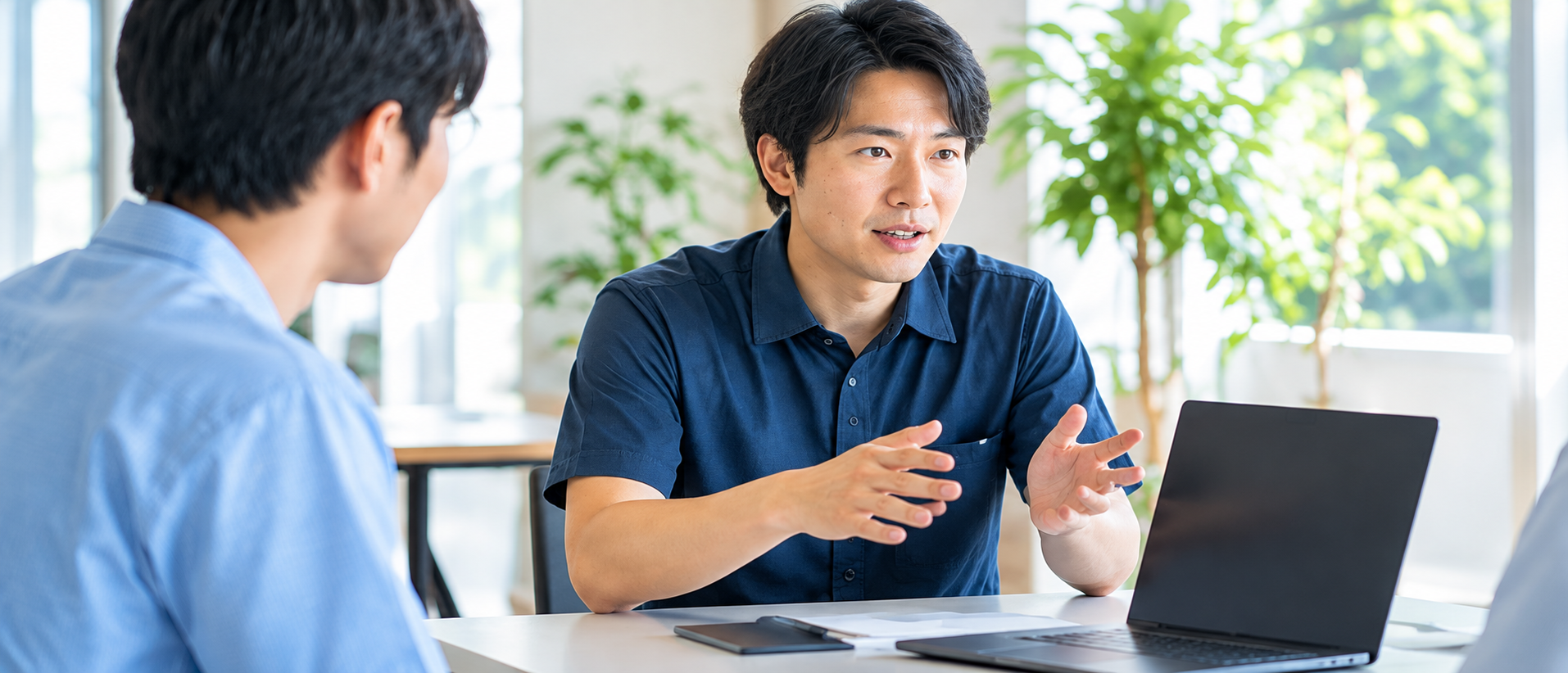 ノートパソコンを前に打ち合わせをするスタッフ